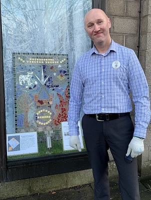 Tesco Manager in front of Springfield Primary School's Mosaic