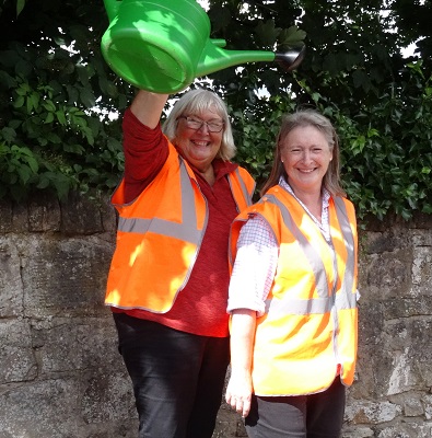 Two volunteers having fun with a watering can